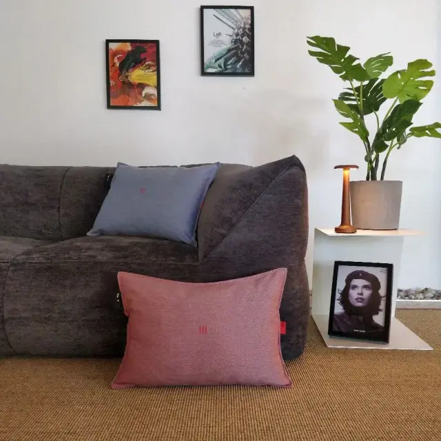 Femme se relaxant avec le coussin chauffant heatme HOME bleu ciel sur un canapé